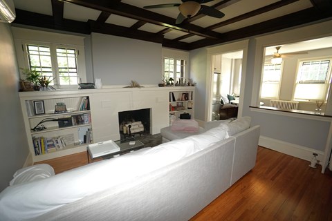 A living room with a fireplace and a white couch.